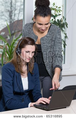 Two Women In Front Of A Notebook