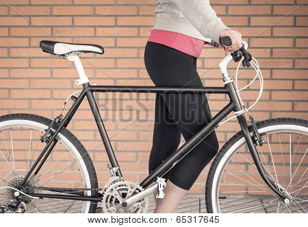 Customized fixie bike and woman over brick wall