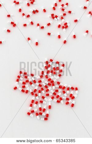 Red and white pills arranged in the shape of a cross