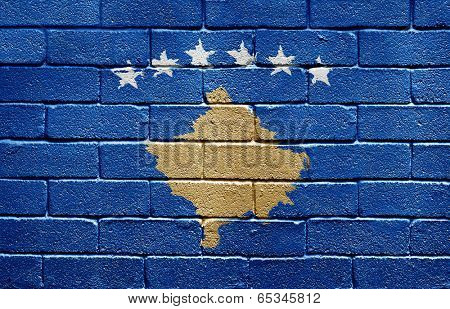 Flag of Kosovo painted onto a grunge brick wall