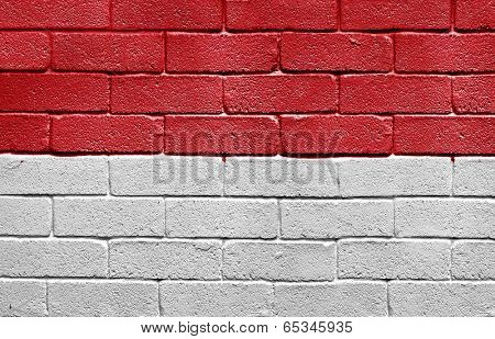 Flag of Monaco painted onto a grunge brick wall