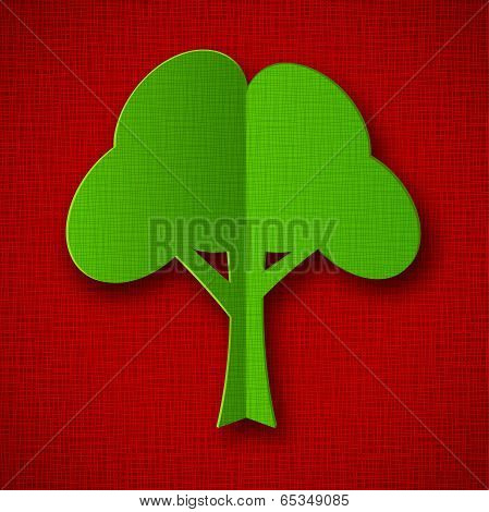 Green paper tree on dark red background