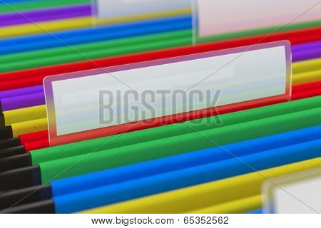 Multi colored hanging folder with blank tag on it