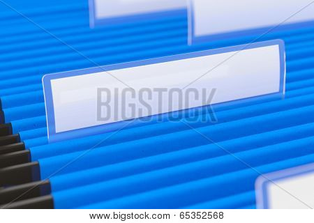 Blue hanging folder with blank tag on it