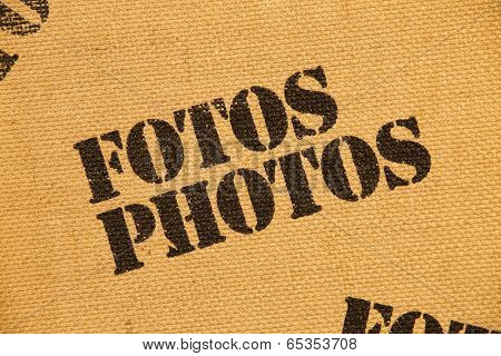 Close up of an album cover made of burlap with the words Photos and Fotos printed on it