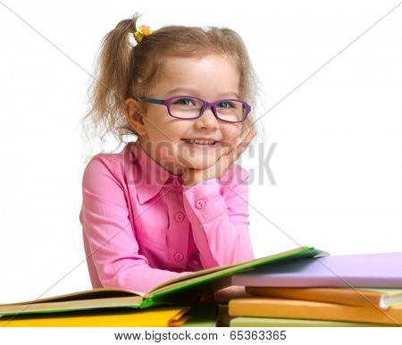 Happy smiling kid girl in glasses reading books sitting at table