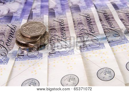 Spread Of Twenty British Pound Notes And A Stack Of Coins