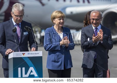 BERLIN, GERMANY - MAY 20, 2014: German Chancellor Angela Merkel (C), Turkish Minister of transport Lutfi Elvan (R) open up the International aviation and space exhibition ILA. 