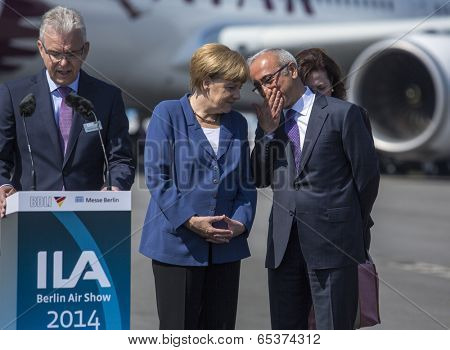 BERLIN, GERMANY - MAY 20, 2014: German Chancellor Angela Merkel (C), Turkish Minister of transport Lutfi Elvan (R) open up the International aviation and space exhibition ILA.