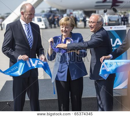 BERLIN, GERMANY - MAY 20, 2014: German Chancellor Angela Merkel (C), Turkish Minister of transport Lutfi Elvan (R) open up the International aviation and space exhibition ILA.