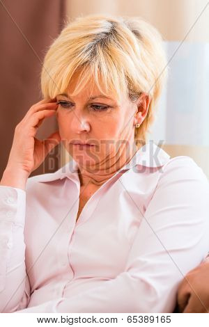 Old woman touching forehead having headache or migraine