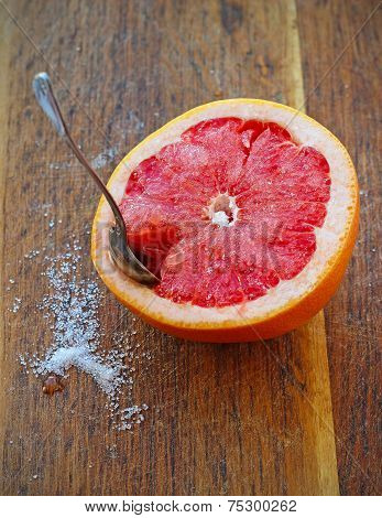 Sliced Grapefruit With Sugar On Wooden Plank