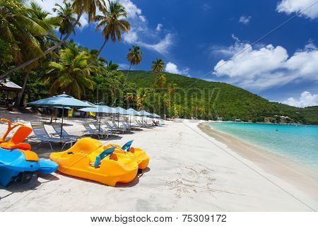 Beautiful tropical beach with palm trees, white sand, turquoise ocean water and blue sky at Tortola, British Virgin Islands in Caribbean