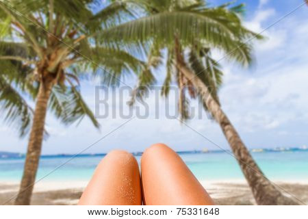 woman's legs on tropical beach and sea background, summer vacation