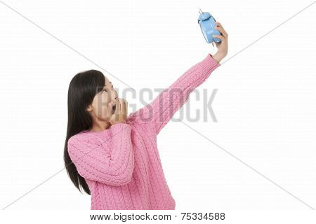 Beautiful Chinese Woman Holding A Blue Alarm Clock