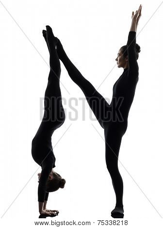 two women contortionist practicing gymnastic yoga in silhouette on white background
