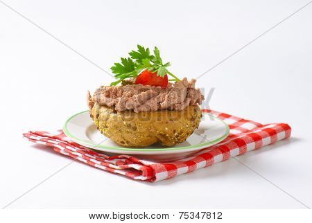 fresh bun with pate, cherry tomato and parsley on white plate and checkered dishtowel
