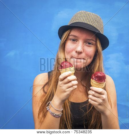 Portrait of teengirl with ice cream, blue wall background (Instagram style series)