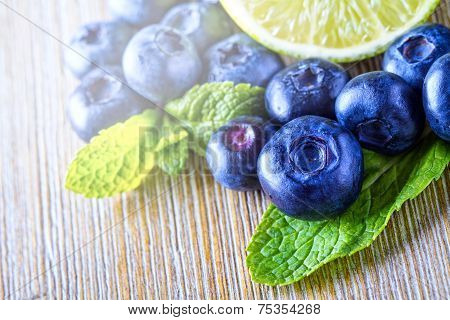 Fresh blueberries green leaves, citrus fruit - lemon limet