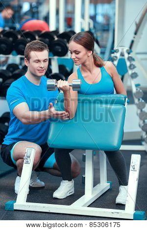 Beautiful girl in sports club with instructor