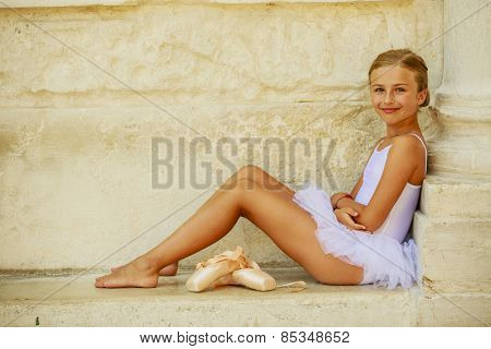 Beautiful ballet-dancer in white dress and pointe shoes dancing in Venice Italy