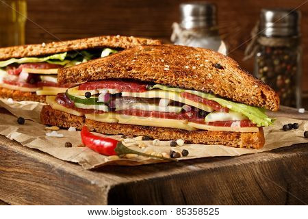 Two Pieces Of Club Sandwich On Old Papper With Big Cutting Board. In Vitage Style.