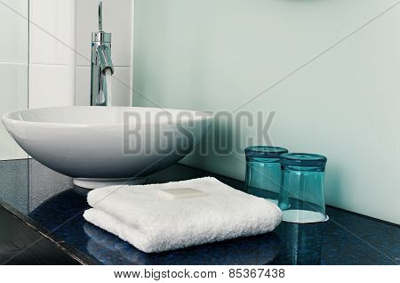 Bathroom sink counter towels water glass blue