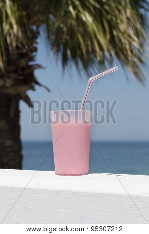 Pink Beverage In Plastic Cup Against Blue Sea And Sky