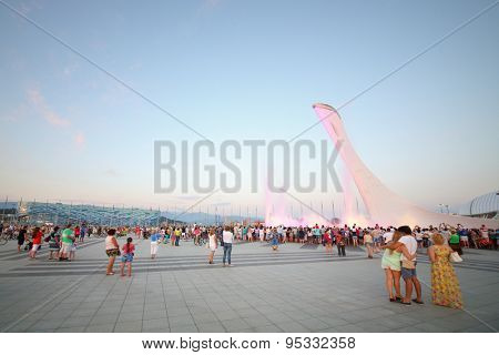 SOCHI, RUSSIA - JUL 27, 2014: Crowds of tourists in the park with a bowl of the flame and singing Fountain in the evening