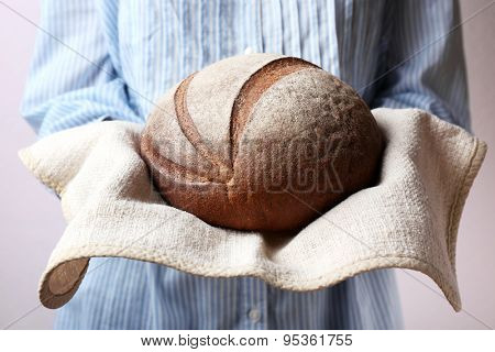 Woman holding tasty fresh bread, close up