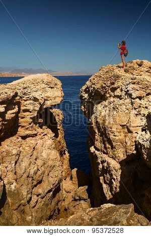 Young lady taking picture from top of the cliff in the National Park of Ras Muhammad, Egypt