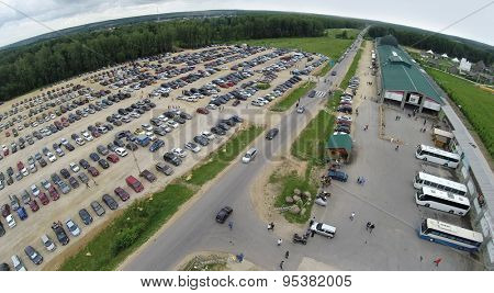 RUSSIA, BOROVSK - 13 JUN, 2014: Large parking with many cars near cultural complex Etnomir at summer day. Aerial view. Photo with noise from action camera