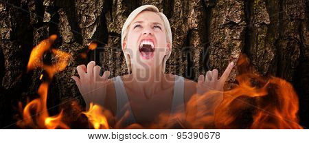 Upset woman screaming with hands up against brown rough bark