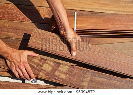 Ipe decking installation with carpenter hands holding tropical wood slats