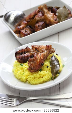 chicken and pork adobo over yellow rice, filipino food