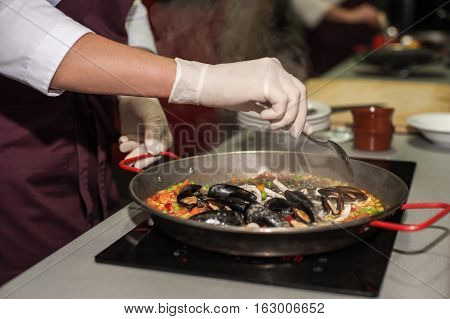 Italian pasta fideua with seafood, oysters, black pasta
