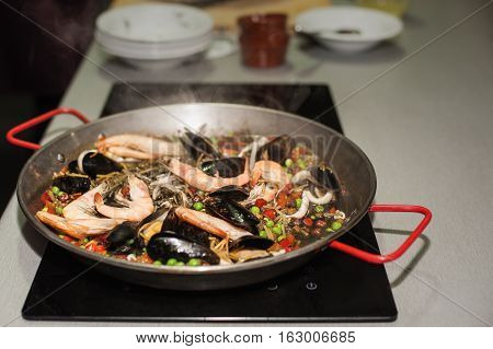 Italian pasta fideua with seafood, oysters, black pasta