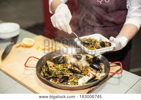 Italian pasta fideua with seafood, oysters, black pasta