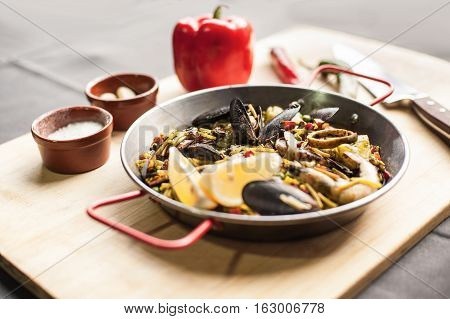 Italian pasta fideua with seafood, oysters, black pasta