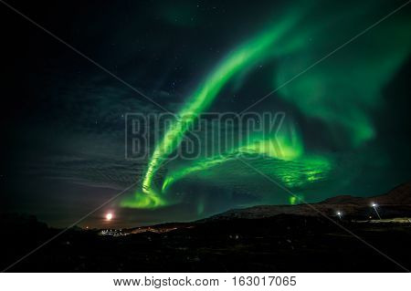 Northern lights and the rising Moon nearby Nuuk city Greenland
