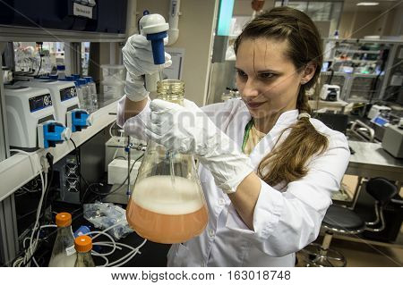 Woman Laboratory Assistant With Flask In His Hand In The Biochemical Laboratory