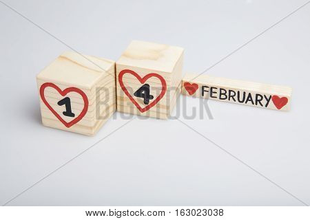 Valentine's day wooden calendar. Handwritten 
February 14th, red hearts. Bright background.