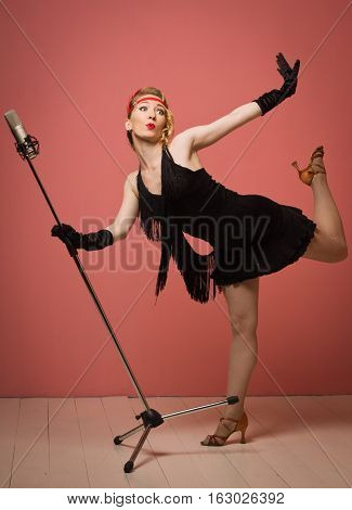 Pretty Actress In Black Retro Dress Singing With Microphone