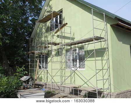 House insulation with styrofoam. Scaffold near the house
