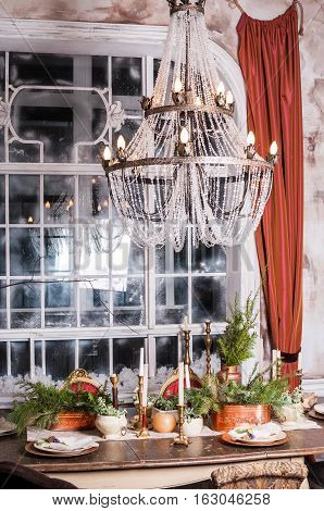 Dining table decorated for Christmas and evergreen centerpiece.