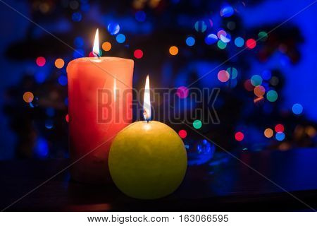 Two burning candles on lighting backgruond. Romantic.