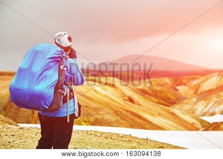 woman hiker photographer taking picture on the rhyolite mountains background in Iceland
