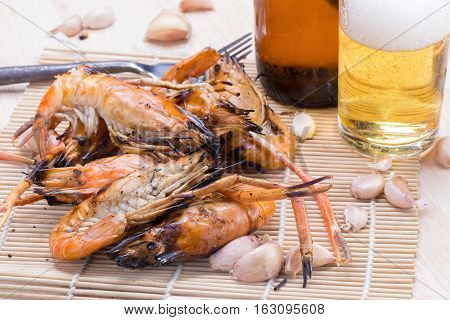 Burn Shrim And Seafood Sauce With Beer On Wooden Table.