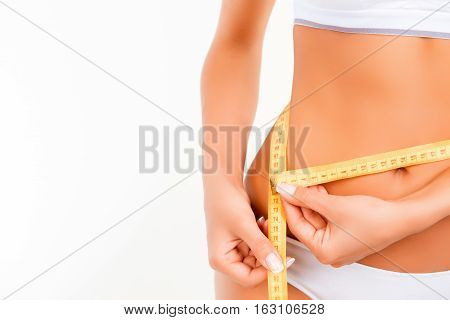 Close Up  Of Slim Woman Measuring Her Waist's Size With Tape Measure