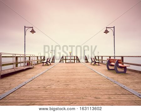 Long Touristic Mole Within Autumn Misty Morning. Wet  Board